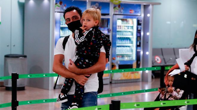 Xavi, con su hijo en brazos, este lunes a su llegada al aeropuerto de El Prat.