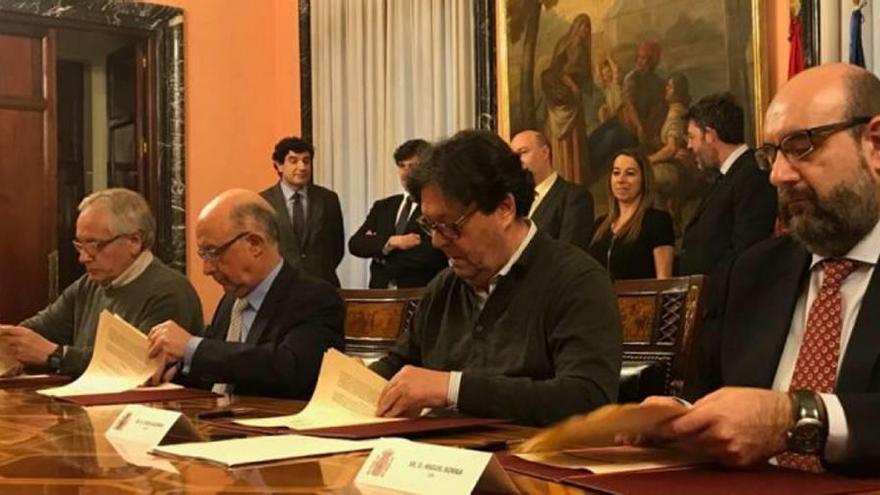 Cristóbal Montoro, segundo por la izquierda, firma el acuerdo con los dirigentes sindicales.