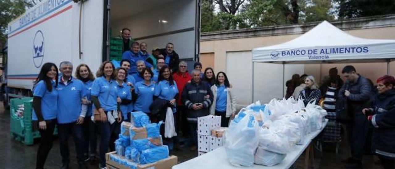 Los voluntarios de CaixaBank, a la izquierda, junto al camión. A la derecha, algunas de las personas que recibieron comida.