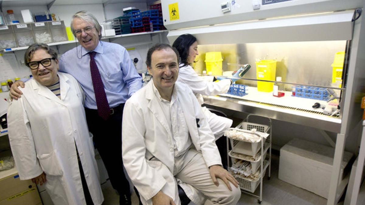 El investigador Felipe García (sentado); el jefe de Enfermedades Infecciosas del Hospital Clinic, Josep Maria Gatell (c), y la doctora Teresa Gallart (i), posan en el laboratorio en el que trabajan.