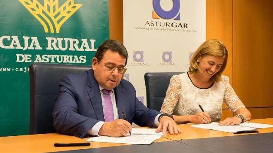 Fernando Martínez, director general de Caja Rural, y Eva Pando, presidenta de Asturgar, firman el convenio.