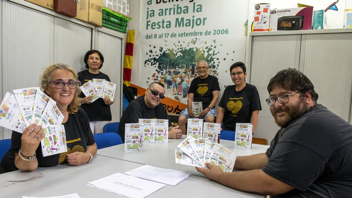 Parte de los integrantes de la comisión de Fiestas de Bellvitge, de izda a dcha., Rosa, Pilar, Jose, Vicente, Lucía y Miguel mostrando el catálogo de las fiestas en su lugar de reunión .