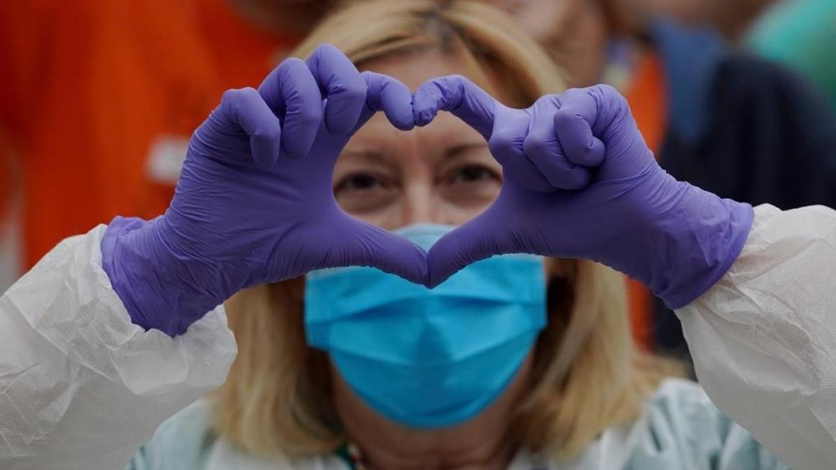 Una enfermera del hospital Gregorio Marañón, de Madrid, hace el signo del corazón con sus manos para agradecer los aplausos a los sanitarios.