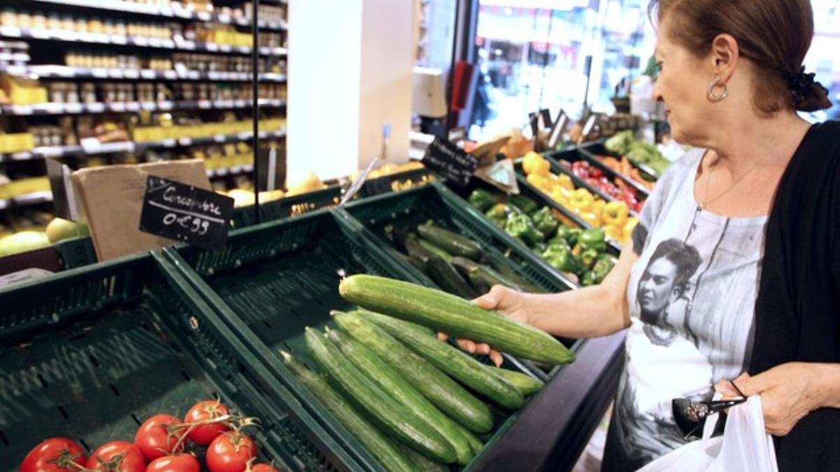 Una mujer compra verdura en un supermercado de París.