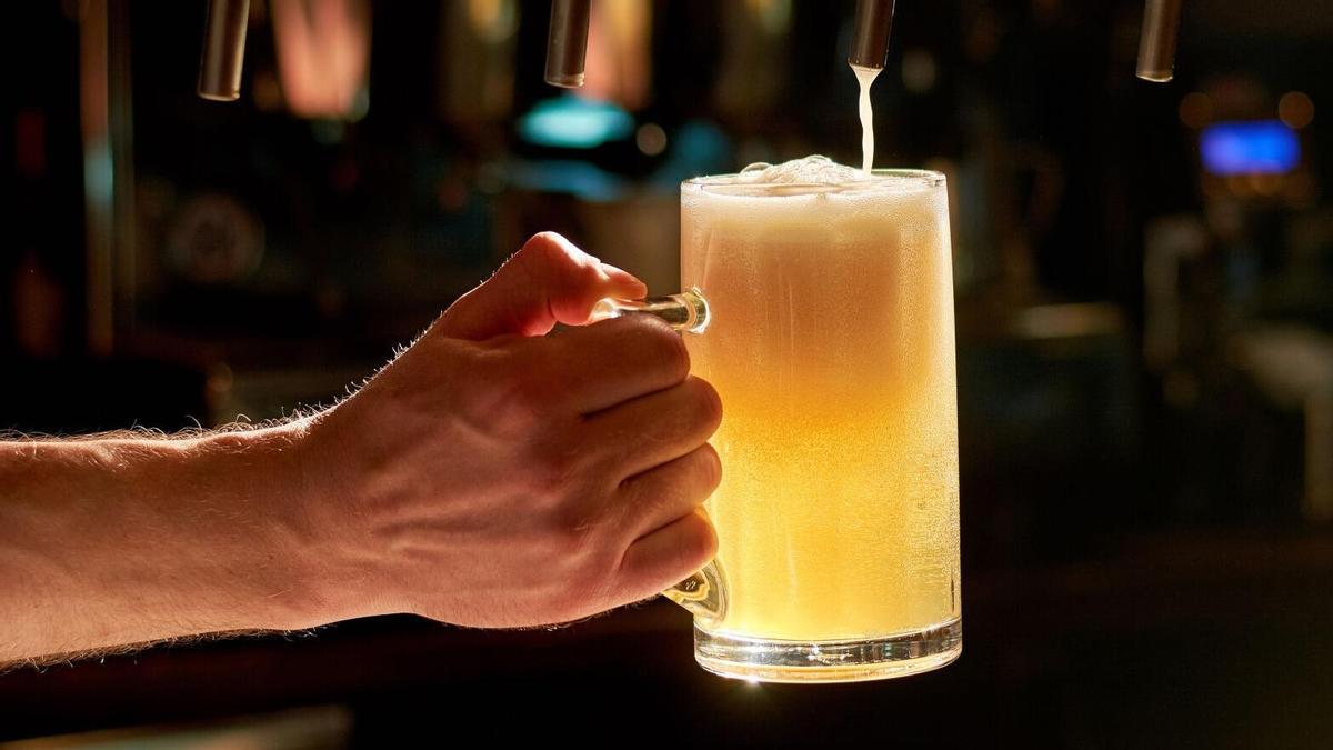 Un camarero llena una jarra de cerveza de un dispensador, en una imagen de archivo.