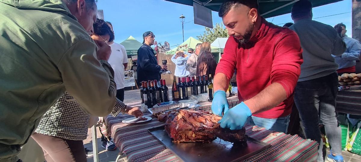 Alejandro Vega, cortando una pata asada para los bocadillos.