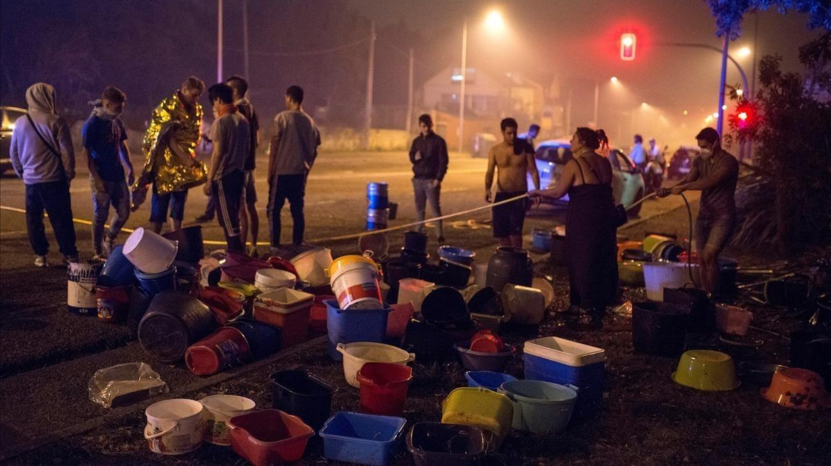 Ciudadanos de Vigo sofocan con cubos de agua un fuego en la ciudad.