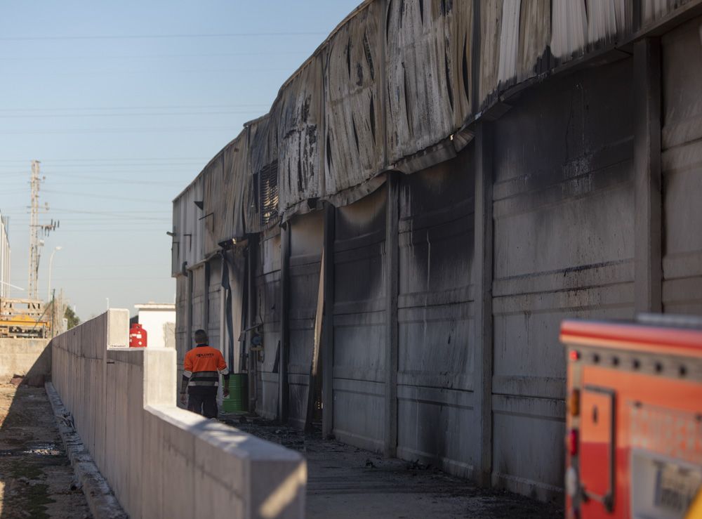 Los bomberos siguen trabajando en la nave del Port de Sagunt un día después del incendio