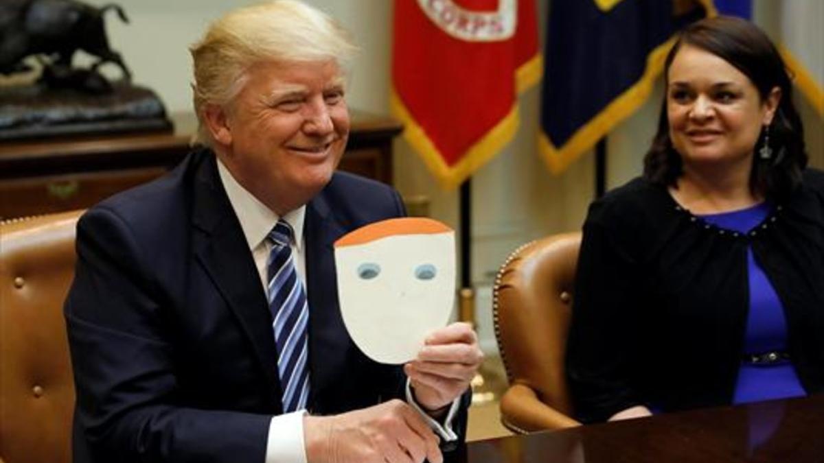 Trump muestra una tarjeta enviada por un niño, en la Casa Blanca.
