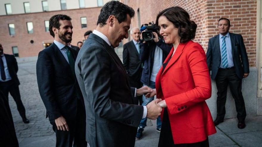 Juanma Moreno saluda a Isabel Díaz Ayuso bajo la mirada de Pablo Casado, en una imagen de archivo