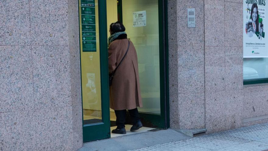 Una mujer entra en una sucursal bancaria en la calle de las Tres Cruces de Zamora.