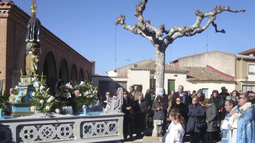 Monaguillos y sacerdotes durante la procesión por una calle de la villa.