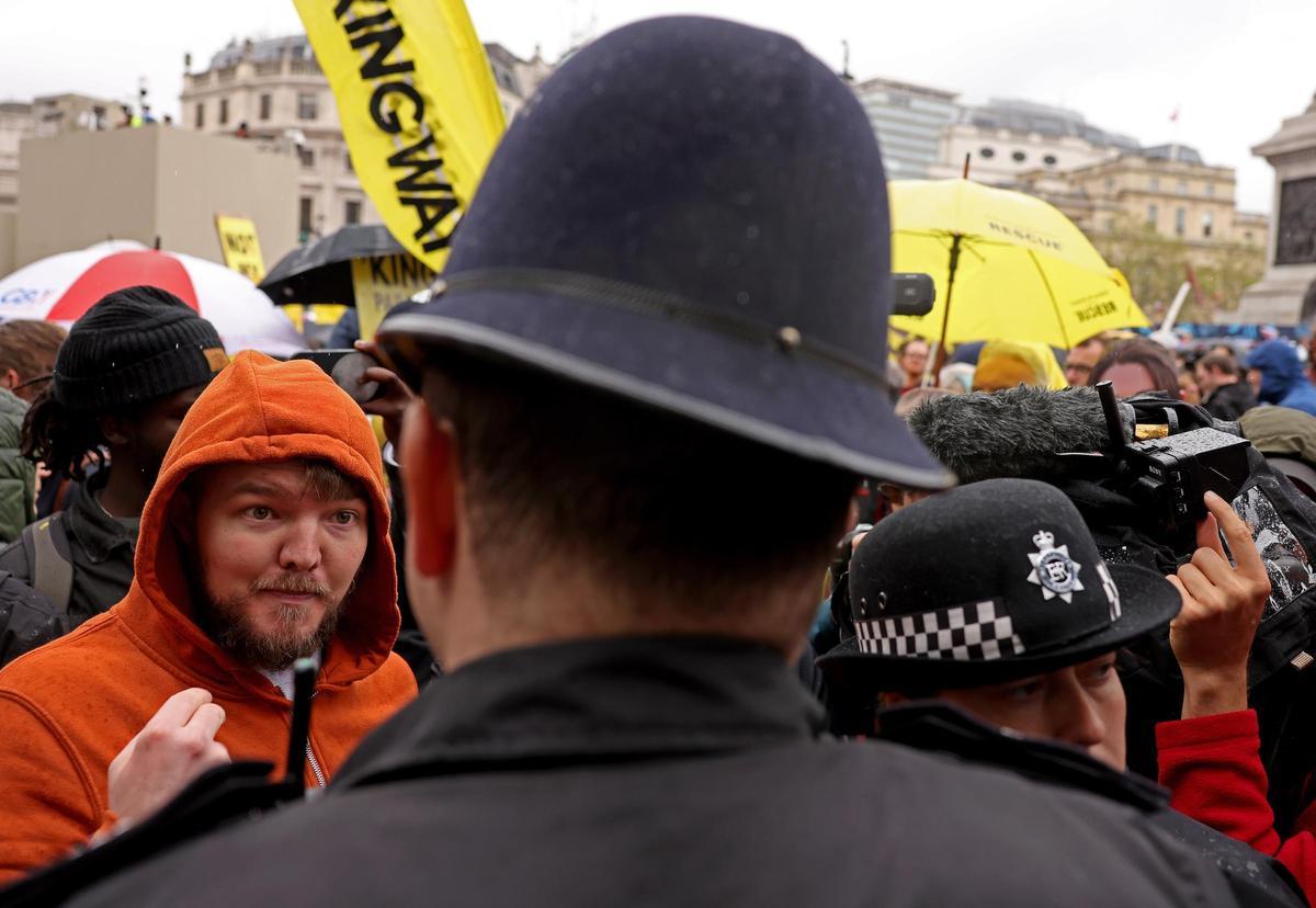 Un hombre habla con un policía durante la protesta de antimonárquicos en el día de la coronación de Carlos III. Un hombre habla con un policía durante la protesta de antimonárquicos en el día de la coronación de Carlos III.