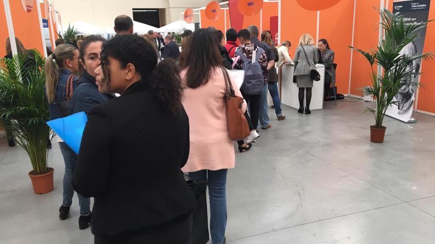 Estudiantes y desempleados hacen cola en uno de los expositores de la Feria de Empleo.