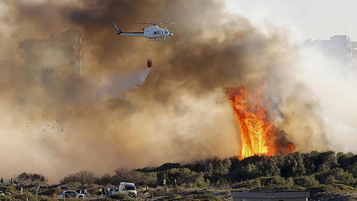Un helicoptero sobrevolando el incendio de El Saler