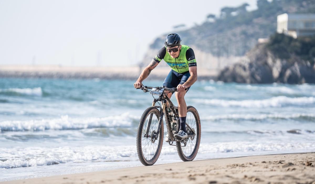 Ciclista de la Mediterranean Epic rodando por la playa de Castellón