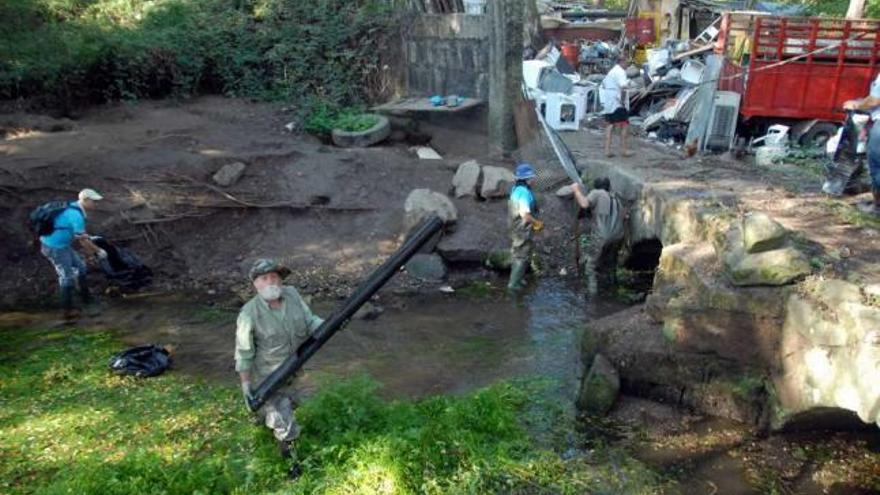 Voluntarios limpian el tramo fluvial de Os Gafos, en Ponte do Couto. / noe parga