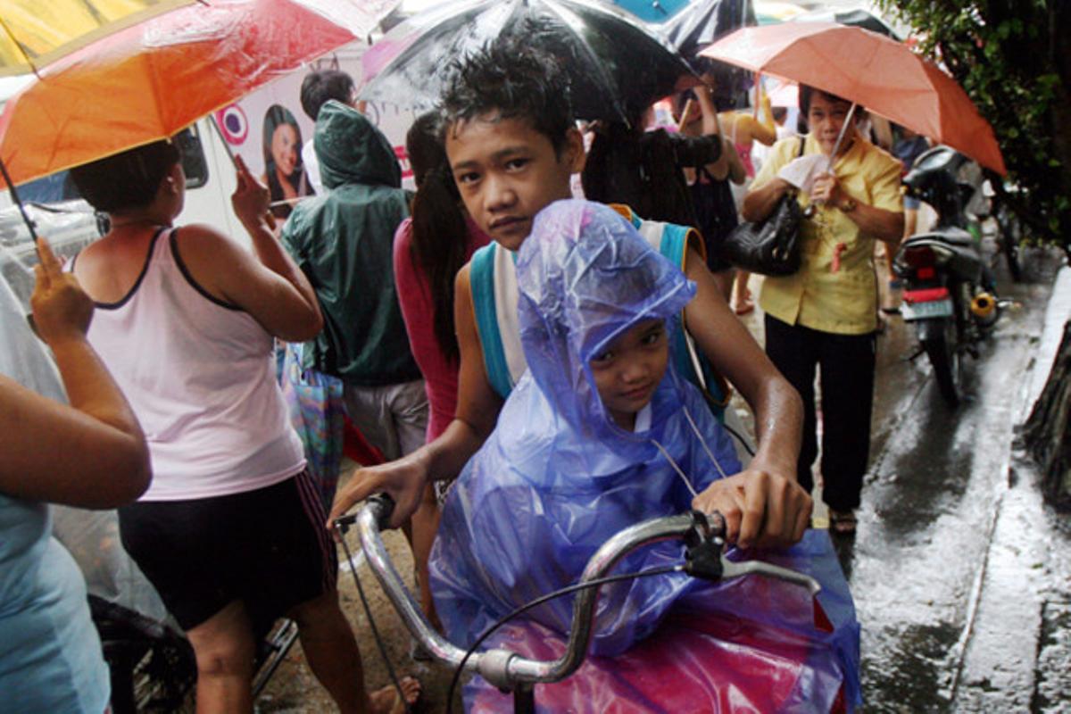 Els vianants es protegeixen de la intensa pluja a Manila (Filipines). Les autoritats filipines han ordenat avui l’evacuació d’unes 100.000 persones, el tancament de les escoles i la cancel·lació de vols davant l’arribada del tifó ’Nesat.’