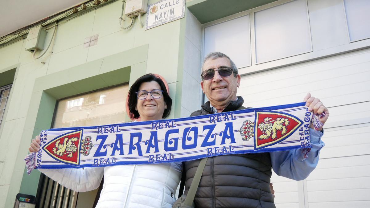 Carmen y José María posan sonrientes debajo de la placa de la calle Nayim y con la bufanda del Real Zaragoza.