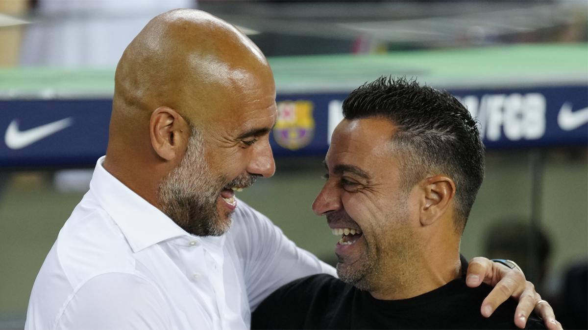 Guardiola sonríe con Xavi antes del partido