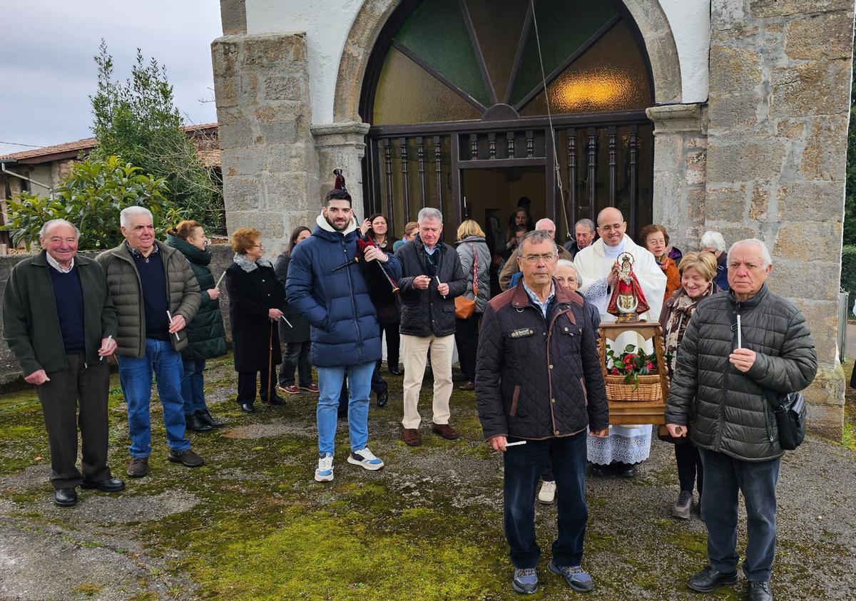 Salida de la procesión de La Candelaria en Poreñu, portada por Modesto Novoa (izquierda), Alejo Baños, Berta Martínez y Julia Mari Cardín, en presencia del párroco Ismael Peña y el gaitero Diego Prida.