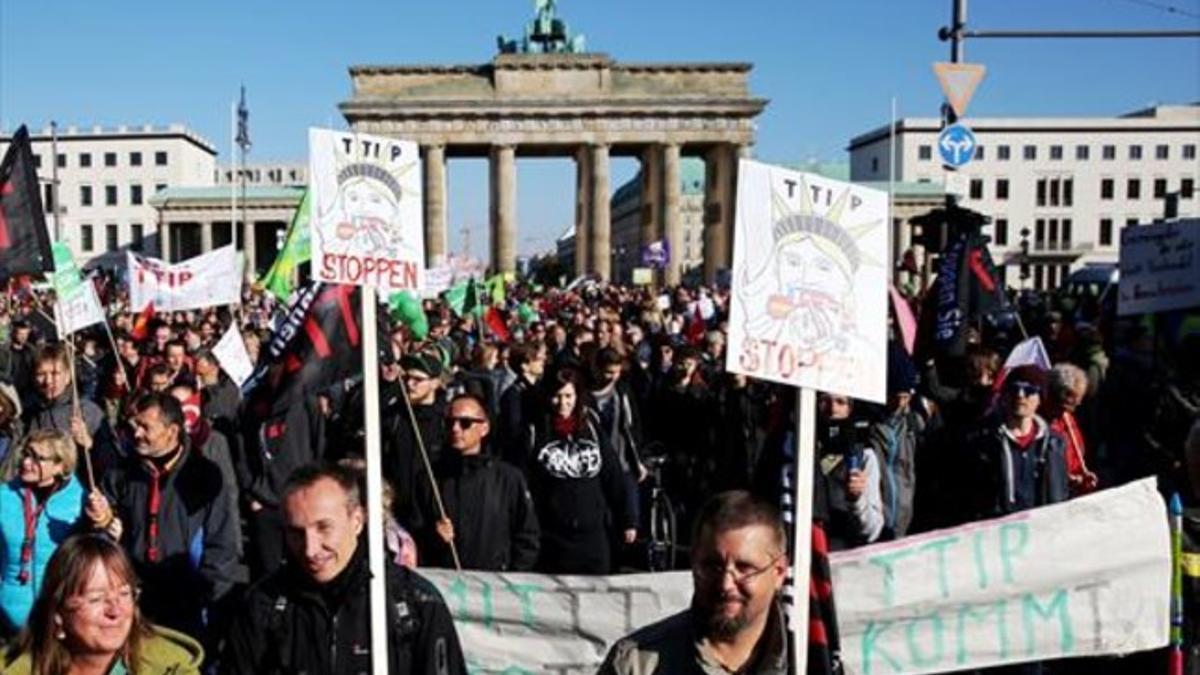 Manifestantes contra el TTIP protestan junto a la Puerta de Brandeburgo, ayer, en Berlín.