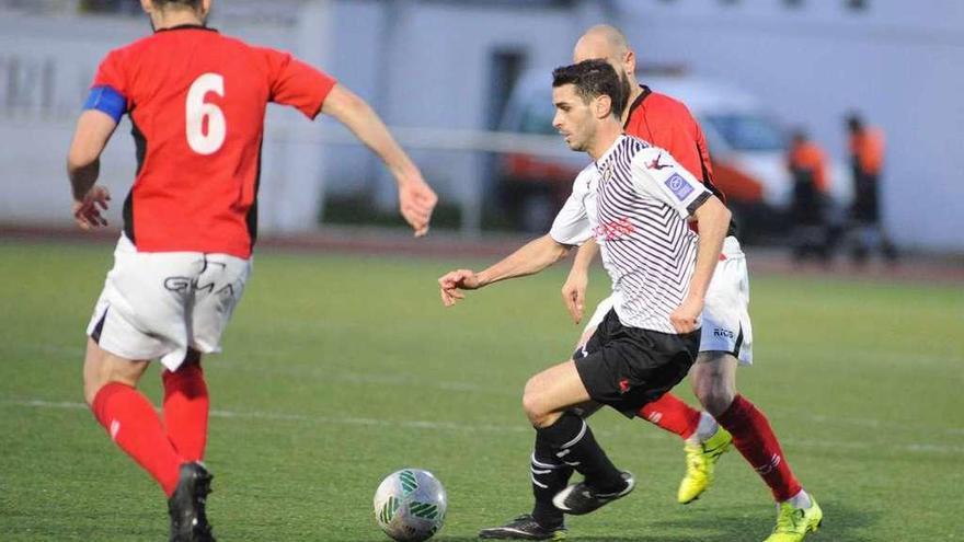 Annunziata controla el balón entre dos jugadores del Tudelano.