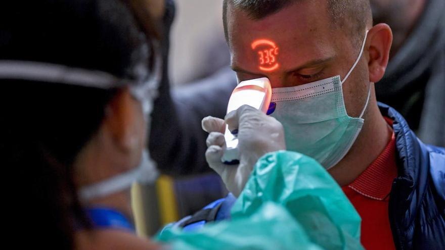 Una sanitaria toma la temperatura a un paciente