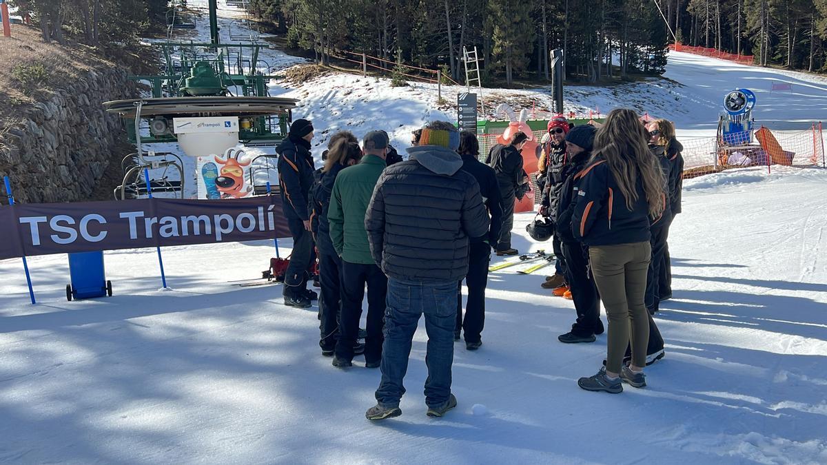 Un grup de treballadors d'FGC de l'estació de La Molina davant del telecadira del Trampolí, aturat per la vaga