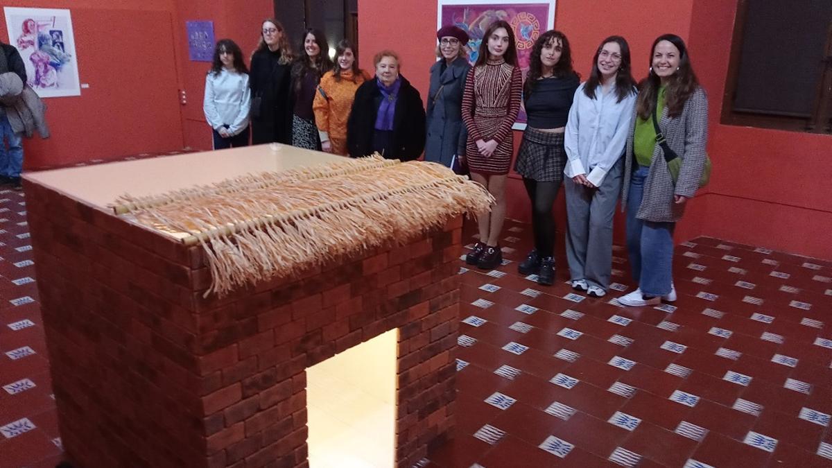 Varias de las artistas que exponen y la comisaria ante una de las obras expuestas