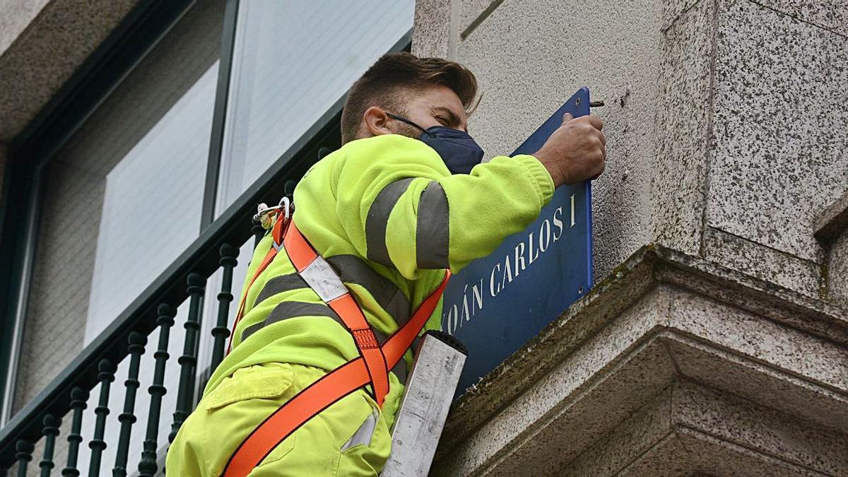 Un operario retira el cartel callejero con el nombre del rey emérito, ayer en Pontevedra.   | // R. VÁZQUEZ