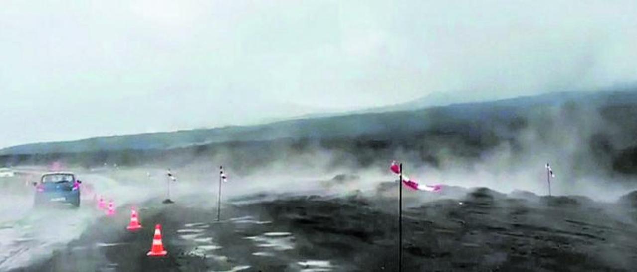 Varios vehículos transitan, entre nubes de vapor, por una carretera afectada por la erupción del volcán de Tajogaite. | | RAMÓN PÉREZ