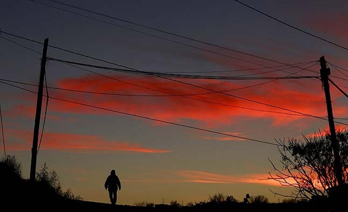 Un home camina per un carrer de Ciudad Juárez al capvespre (Mèxic).