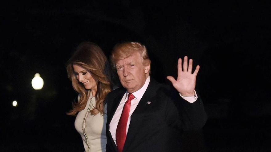 Trump y su esposa, Melania, a su regreso a Washington de la gira.