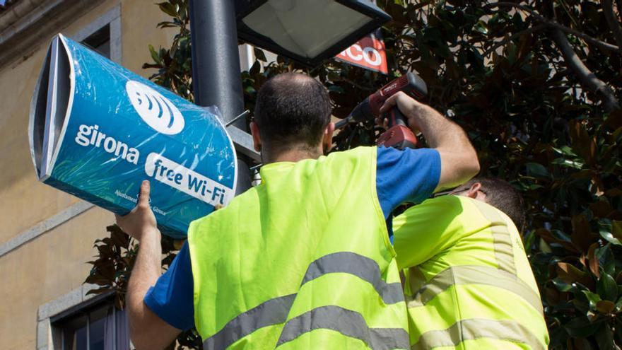 Dos operaris en un punt wifi de Girona.