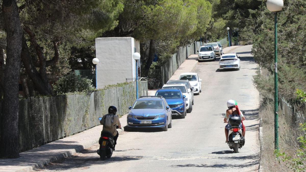 Dos motos sortean uno de los numerosos baches de esta carretera privada. | C.C.