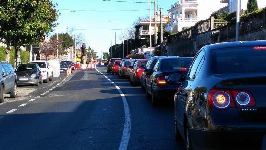 Cola de vehículos parados ante el semáforo, en dirección Santa Cruz.