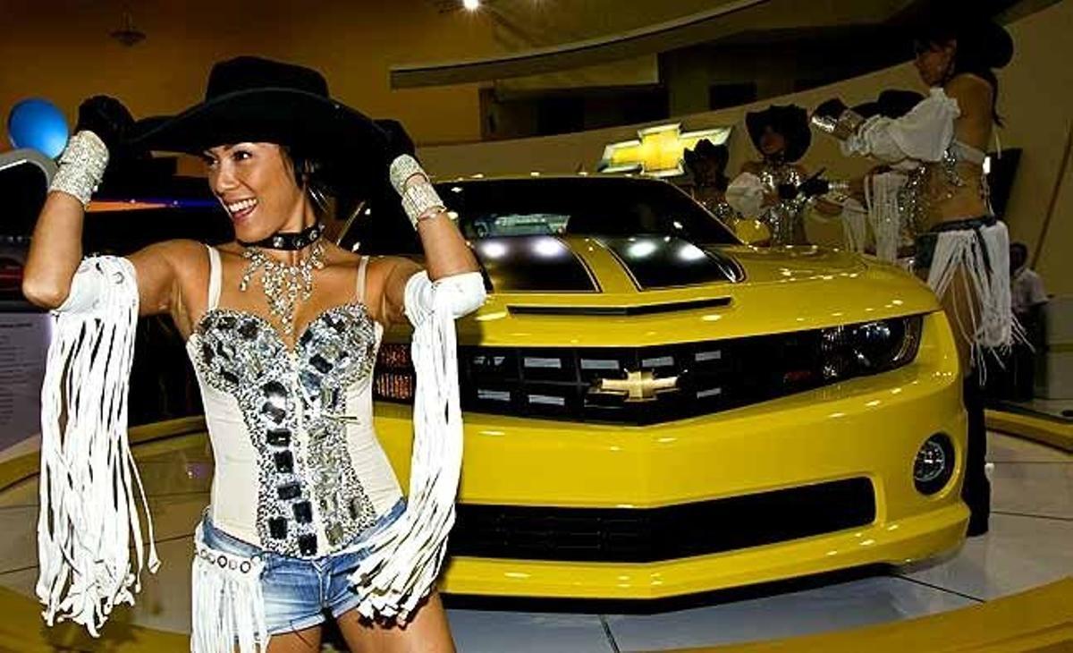Una ballarina actua al costat d’un Bumbblebee Chevrolet Camaro SS durant la Fira Internacional del Motor celebrada a Kuala Lumpur (Malàisia).