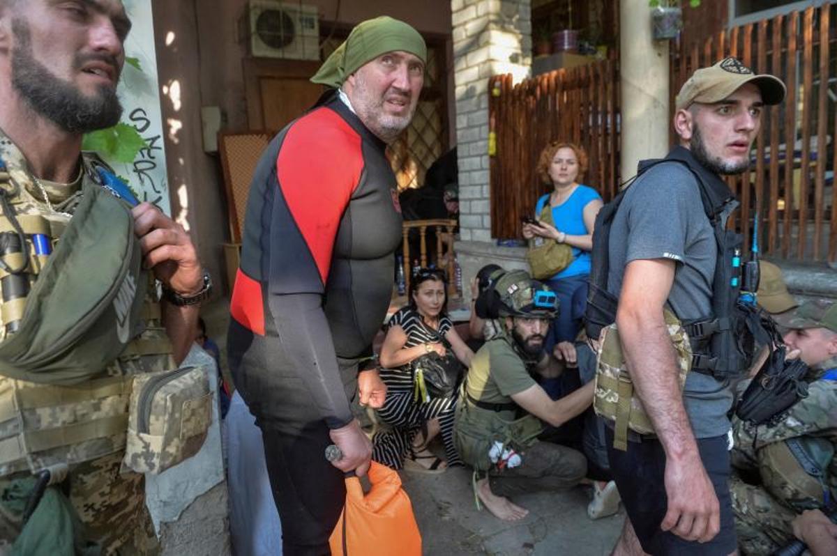 Los voluntarios entregan alimentos a los residentes locales en un área inundada, en medio del ataque de Rusia a Ucrania, en Kherson