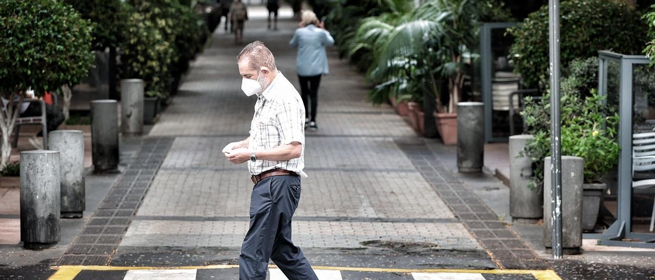 Un hombre con mascarilla camina por Santa Cruz de Tenerife.