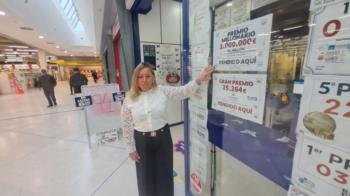 Patricia Sánchez, en su sucursal de Caudalia, mostrando el cartel con el premio.