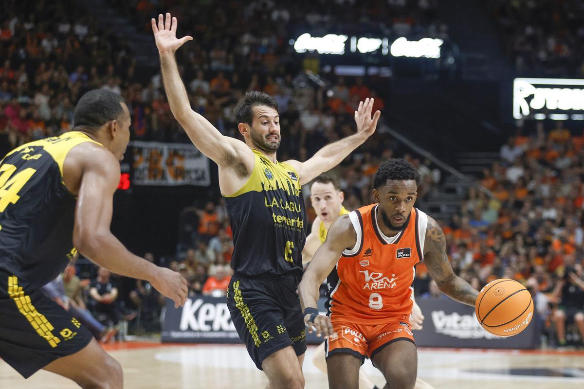 Valencia, 12/06/2025.- The Escort of Valencia Jean Montero (d) plays a ball against Bruno Fitipaldo (C), of Tenerife, during the second match of the semifinal of the Endesa Basketball League that Valencia Basket and the Tenerife Lagoon play this Thursday in the Pavilion of the Fuente de San Luis. EFE/Miguel Ángel Polo