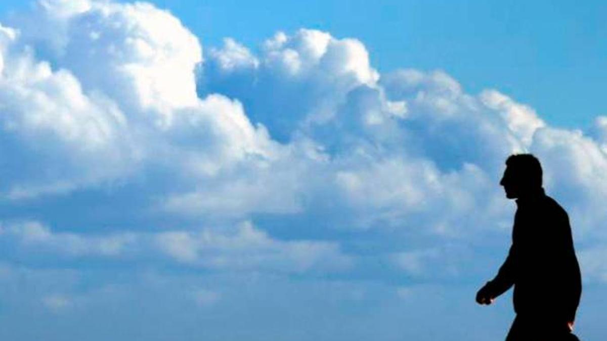 Un hombre pasea con un cielo nublado.