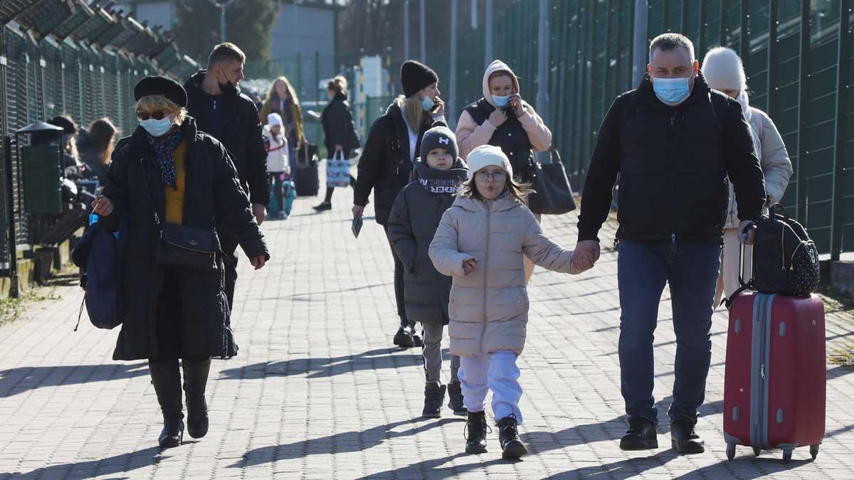 Adultos y niños cruzan la frontera entre Polonia e Ucrania después de que Putin autorizara el ataque a Ucrania