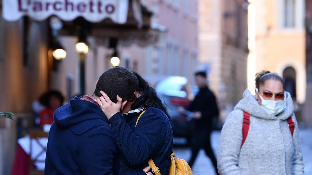 zentauroepp52691170 08 march 2020  italy  rome  a couple kiss while a woman in a200308224851