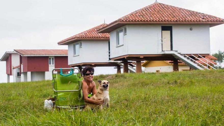 Marián Holgado toma el sol con su perro &quot;Milo&quot; junto a las casas tipo hórreo.