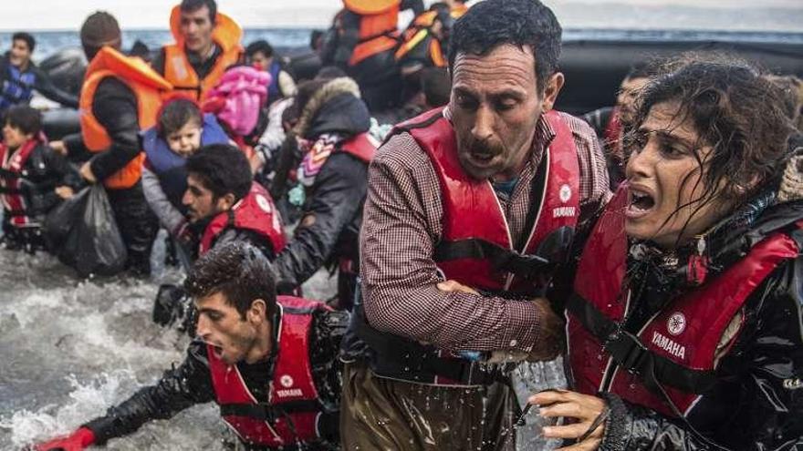 Refugiados saltan de una lancha tras llegar a la costa griega. // Efe