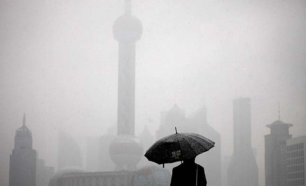 Un home mira el districte financer de Xangai (Xina) durant una tempesta de neu.