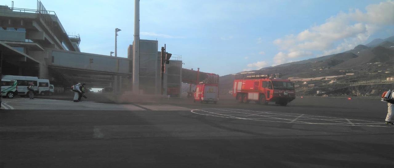 Personal de Aena limpia la ceniza del volcán en el aeropuerto de La Palma.