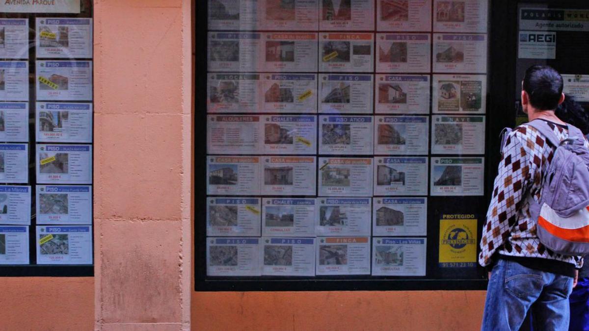 Dos personas observan los pisos ofertados en una inmobiliaria de Zamora. | LOZ